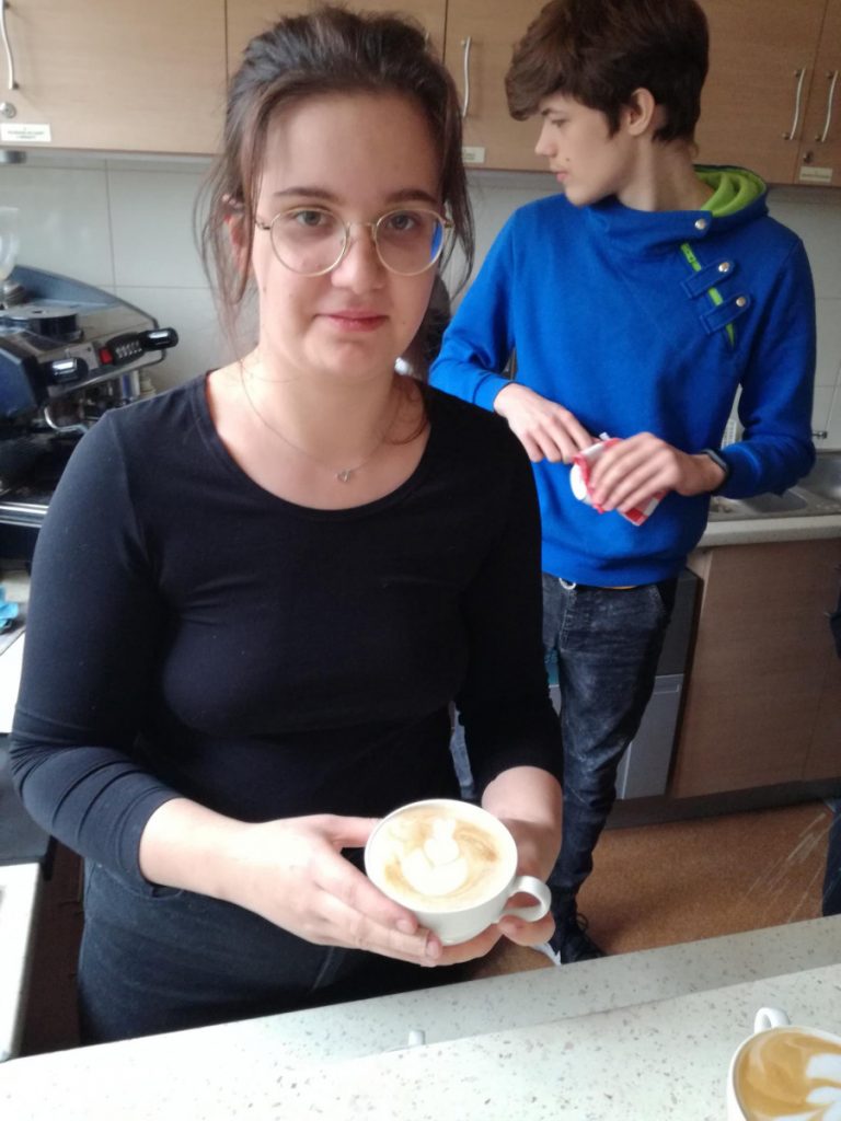Zdjęcie - Uczennica prezentuje wzór tulipana na kawie