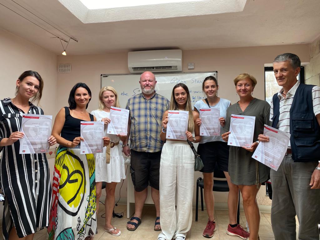 Nauczyciel z Nowej Zelandii z grupą uczestników kursu językowego z Polski, Włoch, Czech i Niemiec trzymających certyfikaty